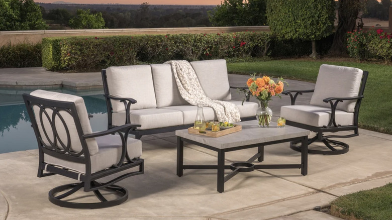 Gün batımı sırasında havuz kenarında siyah metal ve krem ​​rengi bir veranda