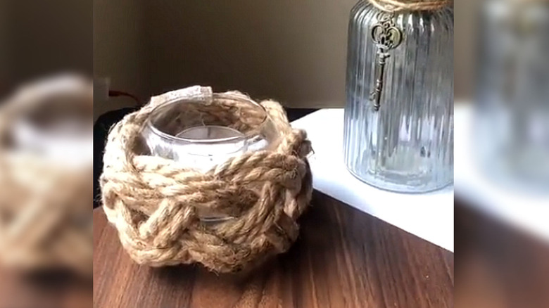 Bir mum tutan rustik ip kaplı cam kase