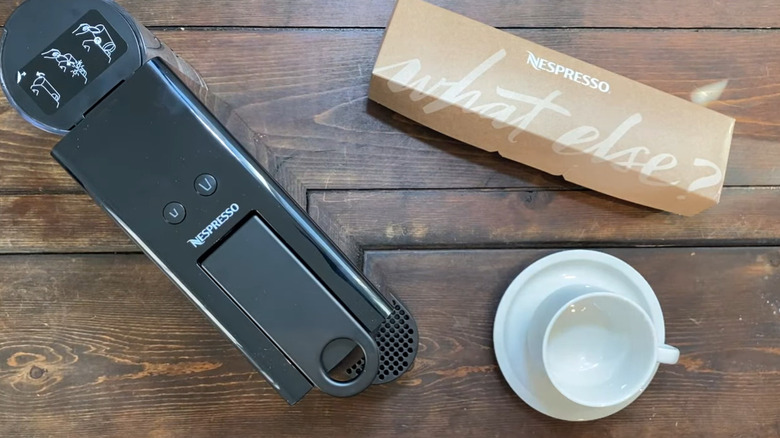 Breville'in ahşap masa üzerinde siyah kaplamalı mini espresso makinesi