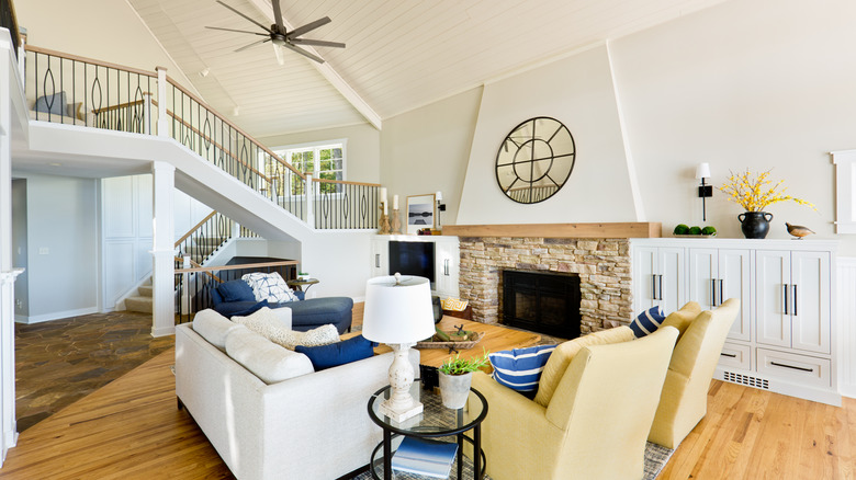 Mavi vurgular ve çizgili yastıklar gibi zarif plaj detaylarına sahip oturma odası