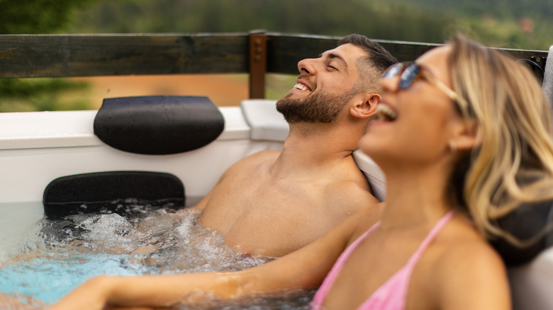 Arka bahçedeki jakuzide sırılsıklam olan bir çift.