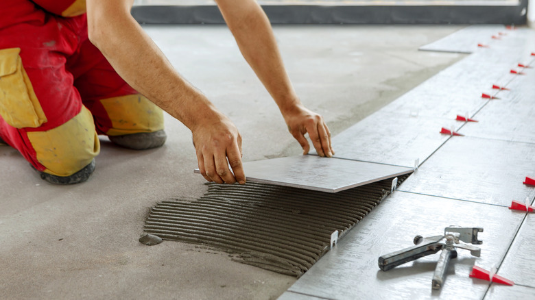 Beton üzerine fayans döşeyen kişi