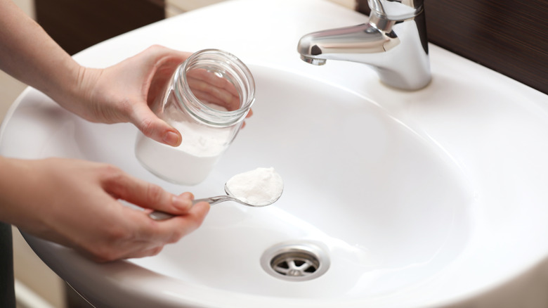 Eller banyo lavabosuna kabartma tozu döküyor.