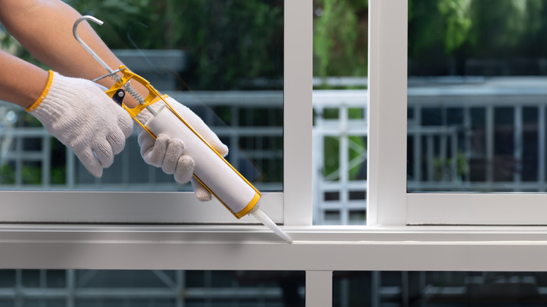 Olası zararlılardan kaynaklanan çatlakların kapatılmasına yardımcı olmak için bir pencere çerçevesi dolduruluyor