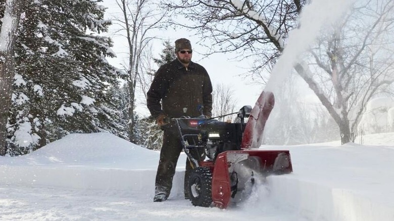 Toro iki aşamalı kar püskürtme makinesi kullanan kişi