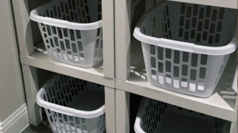 İstiflenmiş IKEA LACK yan masaların altına yerleştirilmiş dört çamaşır sepeti