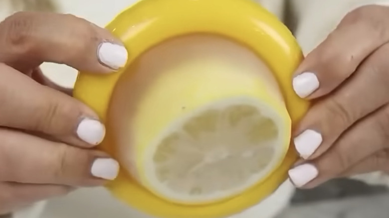 Limon saklama kabı tutan boyalı eller