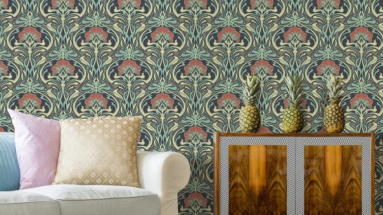 Yan sehpa ve ananasların bulunduğu oturma odasında çiçek yeşili duvar kağıdı tasarımı