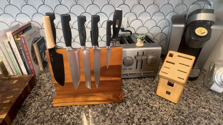 Bir marangoz, üzerine bıçaklar yapıştırılmış manyetik ahşap tezgah standını gösteriyor.