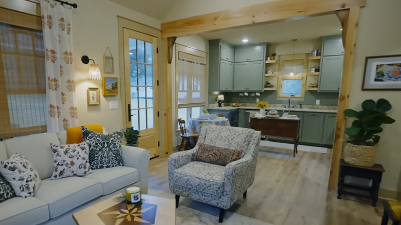 Erin Napier'in "Memleket" oturma odası ile mutfak arasındaki kasalı açıklığın kenarlarında lekesiz ahşap içeren proje