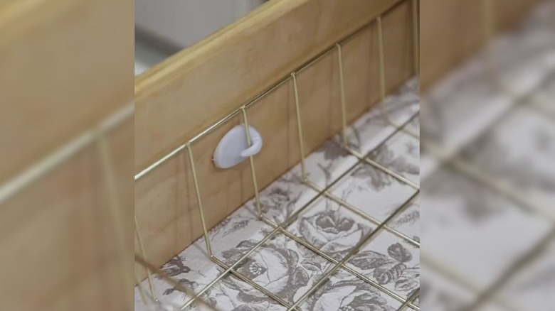 Kendinden yapışkanlı küçük bir kancaya tutturulmuş tel tepsi bölücü