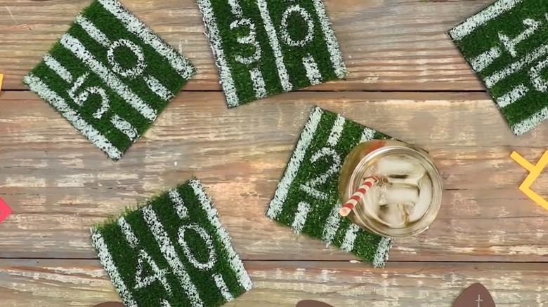 ahşap masanın üzerine boyalı suni çim bardak altlıkları