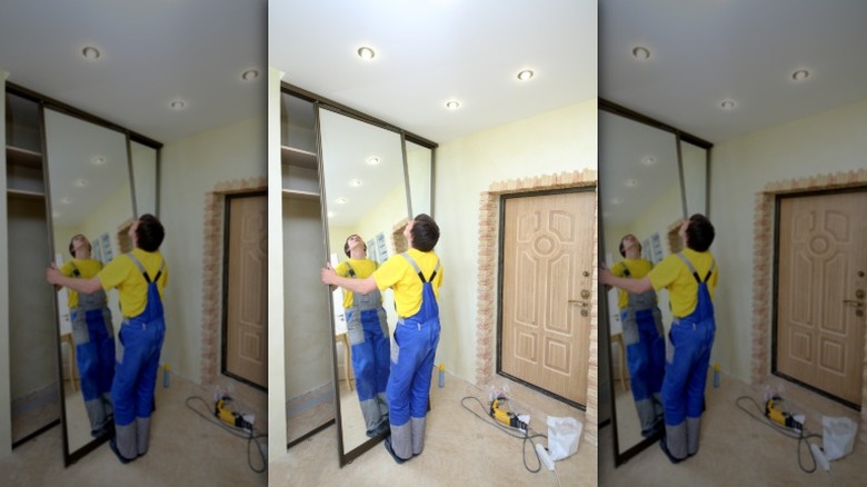 adam sürgülü dolap kapısını takıyor