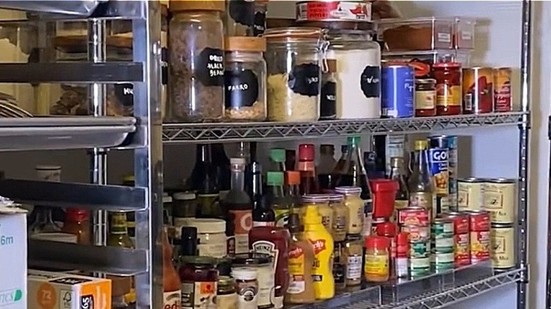 Bobby Flay'in kilerindeki raflar ve metal raflarda çeşitli saklama kapları