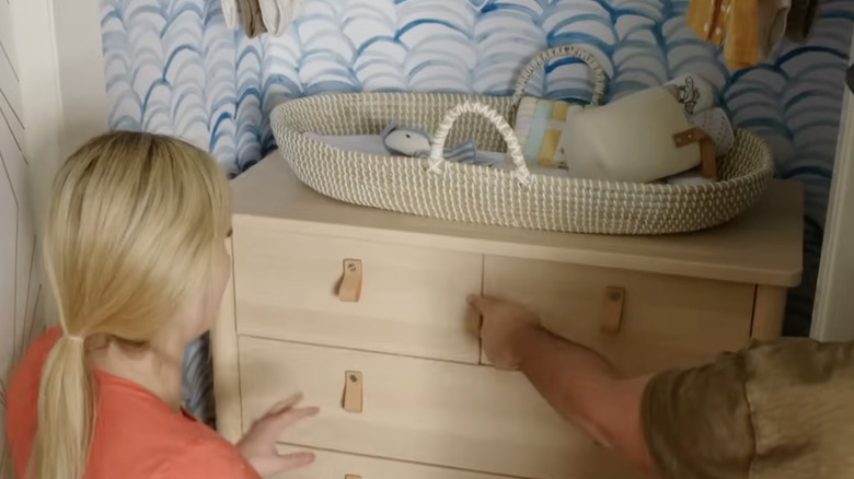 Jasmine Roth ahşap bir şifonyeri dolabın girintisine yerleştiriyor