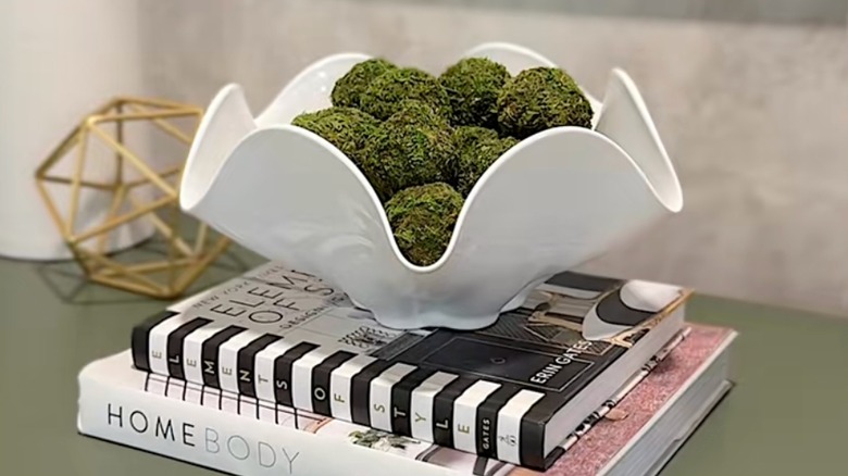 Bir kitap yığınının üzerinde duran cam kase