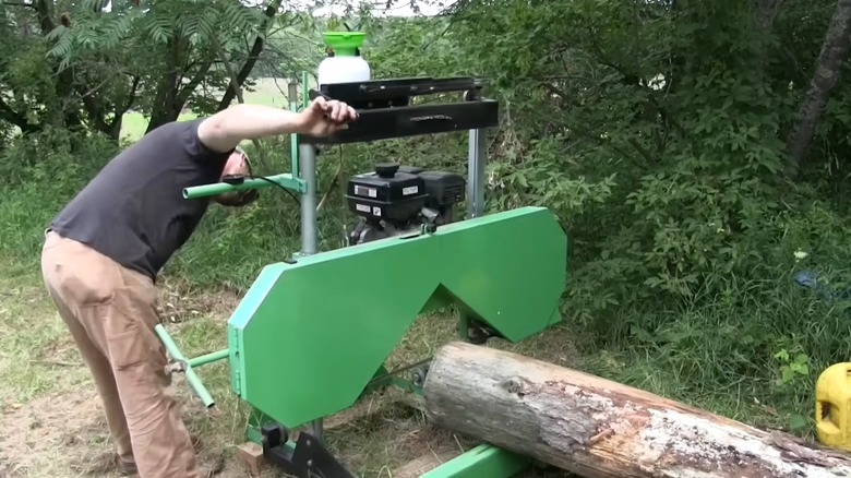 Taşınabilir bir kereste fabrikasında kütüğü çalıştıran adam