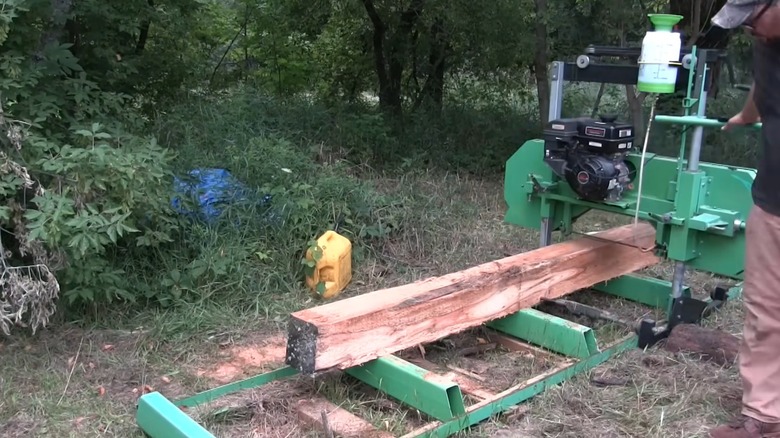 Taşınabilir bir kereste fabrikasında hareket eden kütüğü kesin