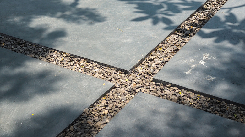 Kaldırım taşı ve çakıldan yapılmış çöp kutuları için ayakta durma alanı