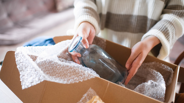 kadın cam vazoyu açıyor