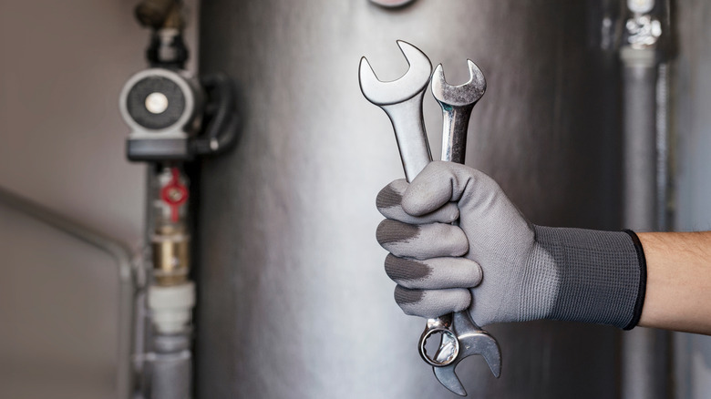 Bir ısıtıcının önünde iki anahtarı tutan eldivenli bir el