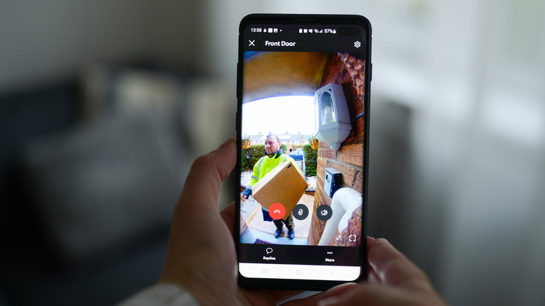 Akıllı telefonundan video kamera yayınına erişen bir kişi
