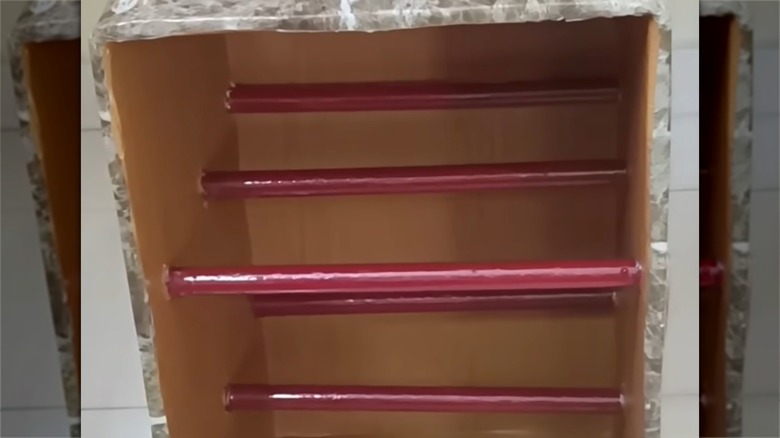 Çubuklar ve karton kutudan yapılmış raflar