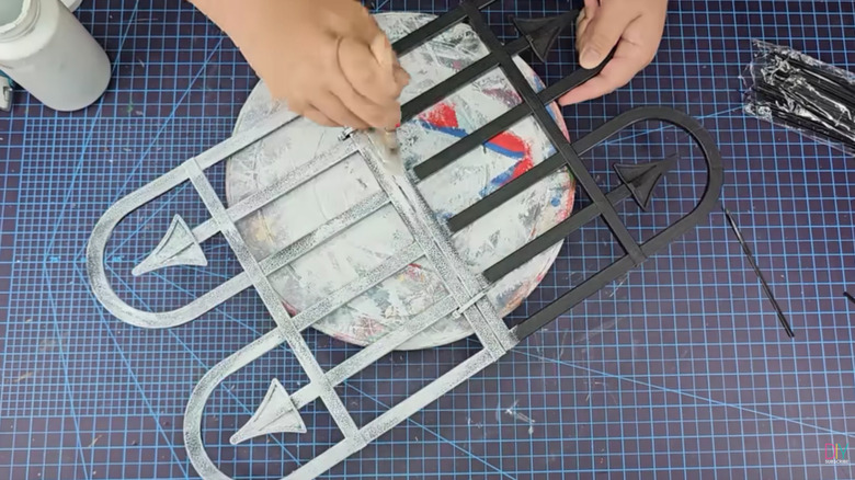 Bahçe çitini beyaza boyayan bir el