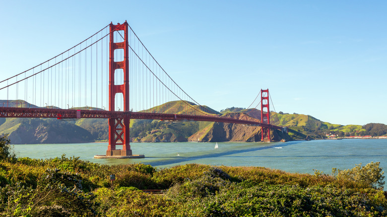 Altından bir yelkenli tekne geçerken San Francisco, Kaliforniya'daki Golden Gate Köprüsü