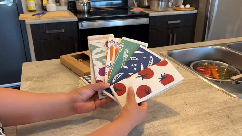 Bir dizi İsveç bulaşık bezi tutan kadın