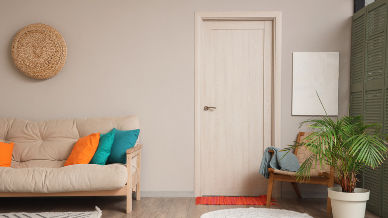 Kapısı duvarla aynı renkte olan bir oturma odası