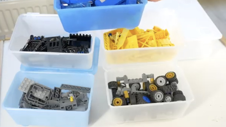 Çeşitli LEGO yapım parçaları ve bileşenlerinin bulunduğu bir IKEA GLIS kutusu seti.