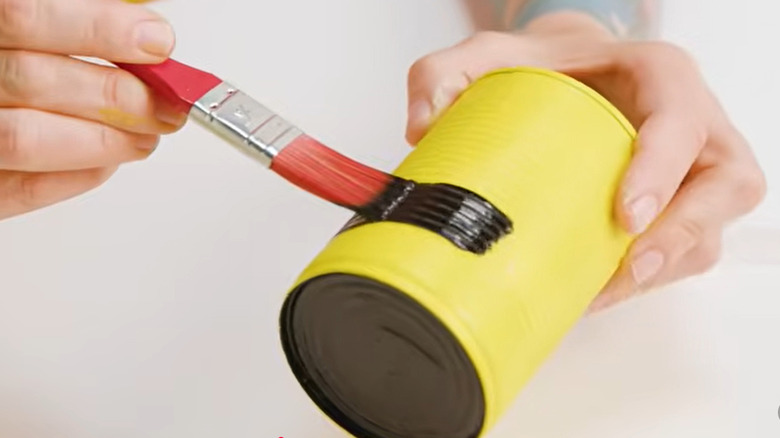 Teneke kutuyu boyayan kişi