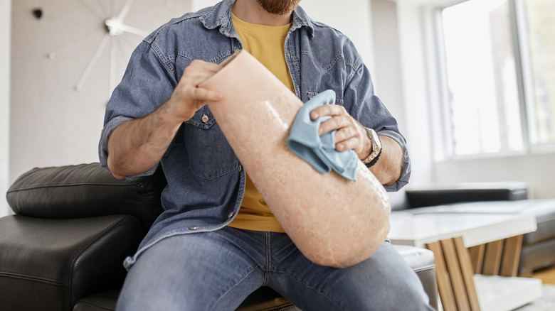 Vazoyu bezle temizleyen adamın yakın çekimi