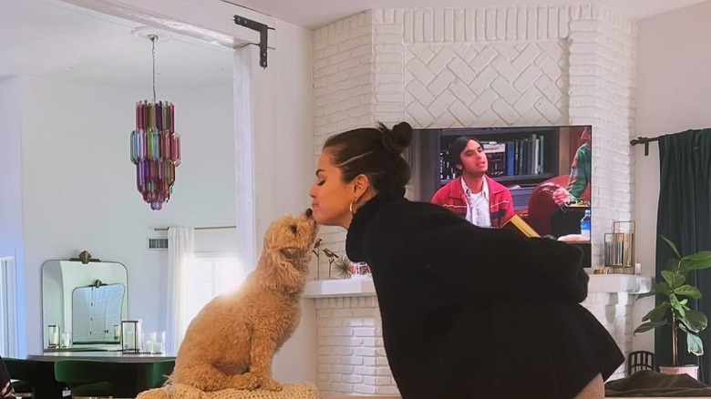 Selena Gomez evinde bir köpeği öpüyor.