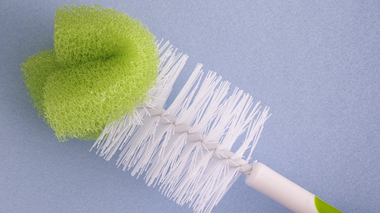 Ucunda sünger bulunan yeşil ve beyaz bir şişe fırçası