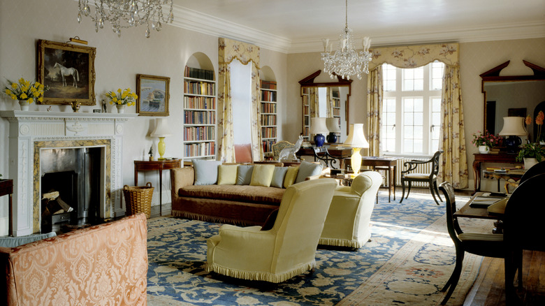 Oturma odasında eski para tarzı iç dekorasyon, kadife kanepeler, ağır perdeler, kristal avizeler ve duvarda sanat eserleri.