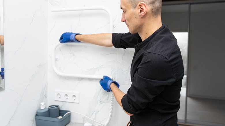 bir uzman havlu ısıtıcısının ısıtma elemanını kurar