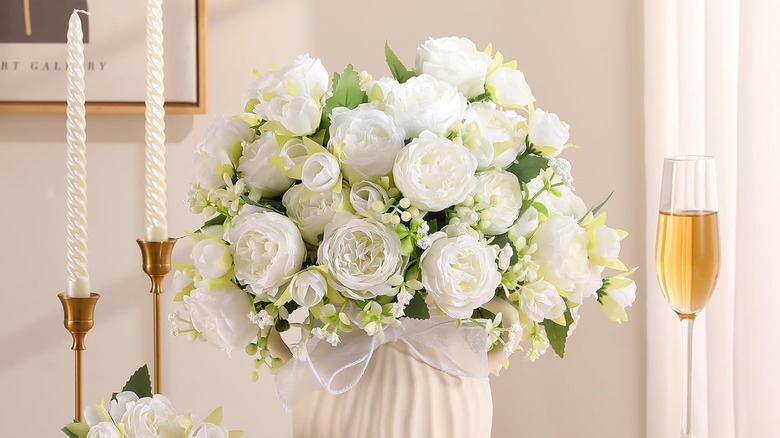 Yemek masasındaki vazoda sahte beyaz şakayıklar