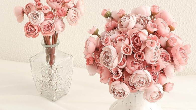 Şeffaf vazolarda sahte pembe düğünçiçeği