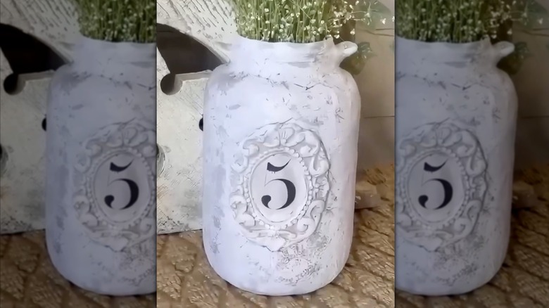 İçinde beş rakamı bulunan dokulu bir plaket içeren, modelleme kilinden yapılmış DIY çömlek kavanozu