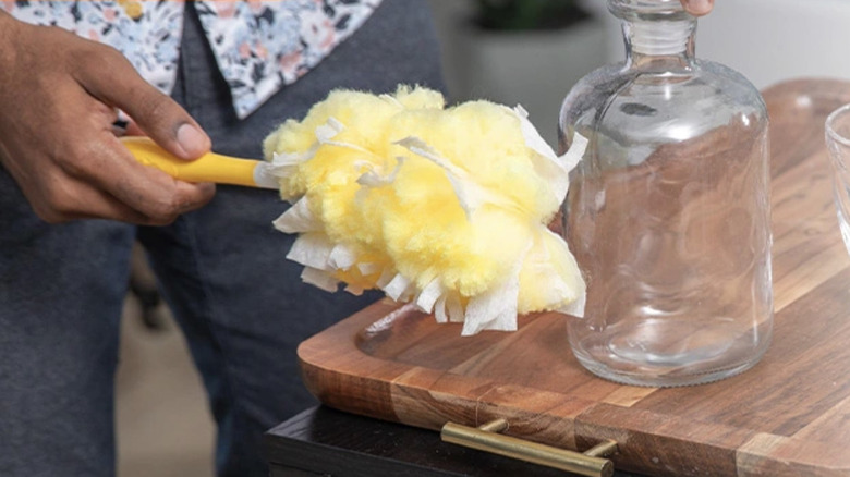 Vazo temizlemek için Swiffer Duster Ağır Hizmet Duster'ı kullanan kişi