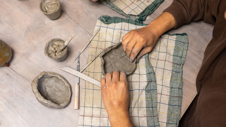 havayla kuruyan modelleme kili üzerinde çalışan biri