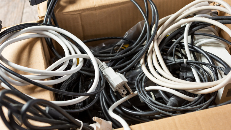 Şarj kablolarıyla dolu karton kutu.