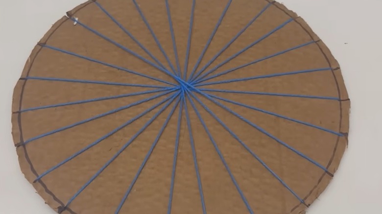 İplik, karton bir daireyi yıldız patlaması şeklinde ikiye böler.