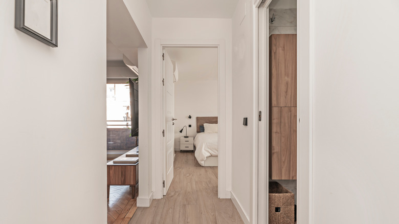 Koridorda yarı açık beyaz cep kapısı ve sonunda yatak odası.