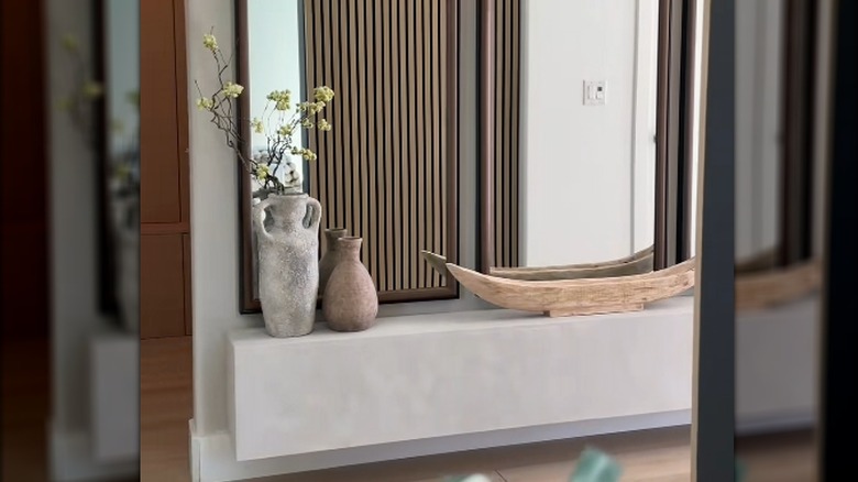 Giriş yolunda alçı kaplı yüzen ocak, üzerinde iki vazo ve bir ahşap parça var