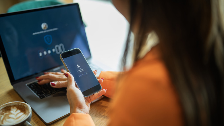 Bir kişi telefona ve klavyeye şifre girer