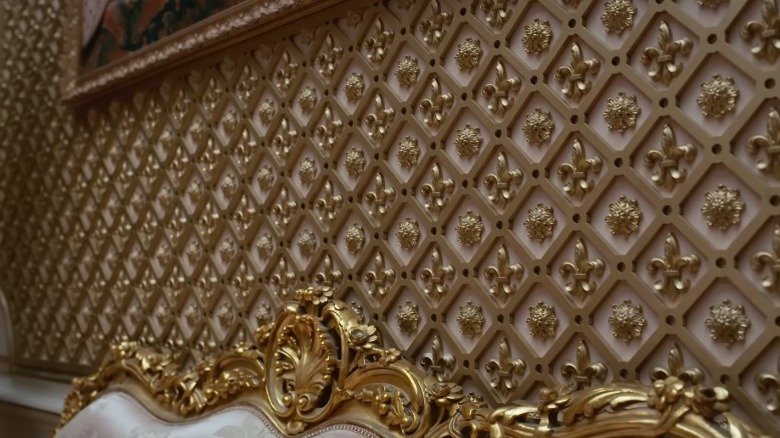 Altın rengi zambak ve çiçek şekilleriyle süslü kafes duvar apliği