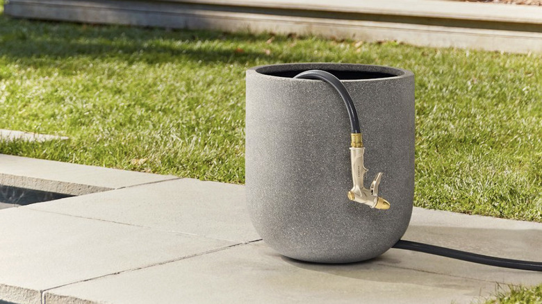 Verandadaki silindirik kapta saklanan hortum